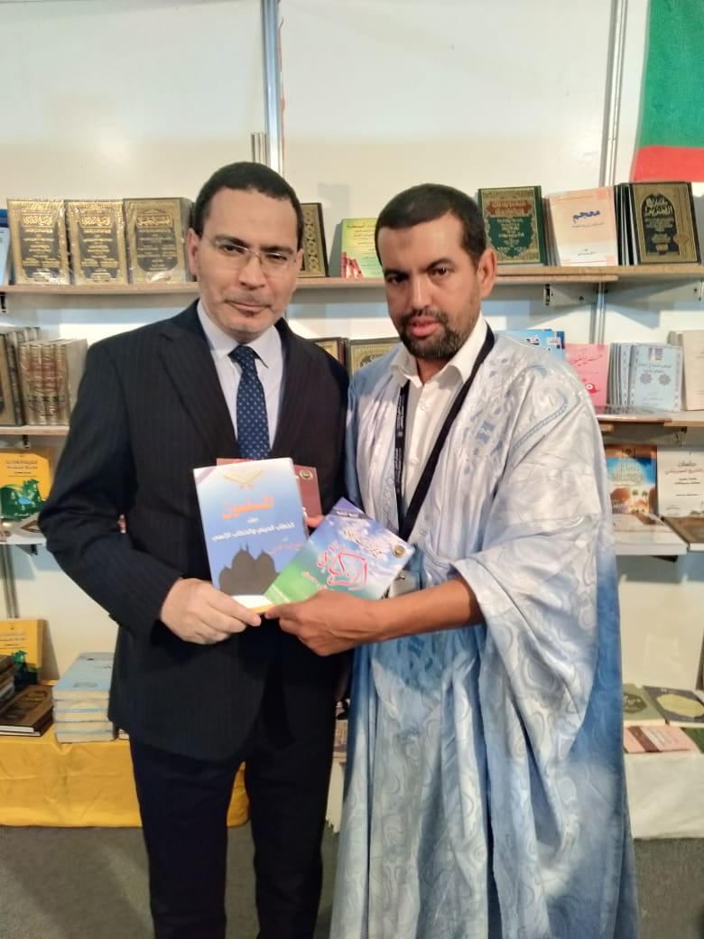 الناطق الرسمي باسم الحكومة المغربية وهو يتسلم  كتب علي محمد الشرفاء المحمادى